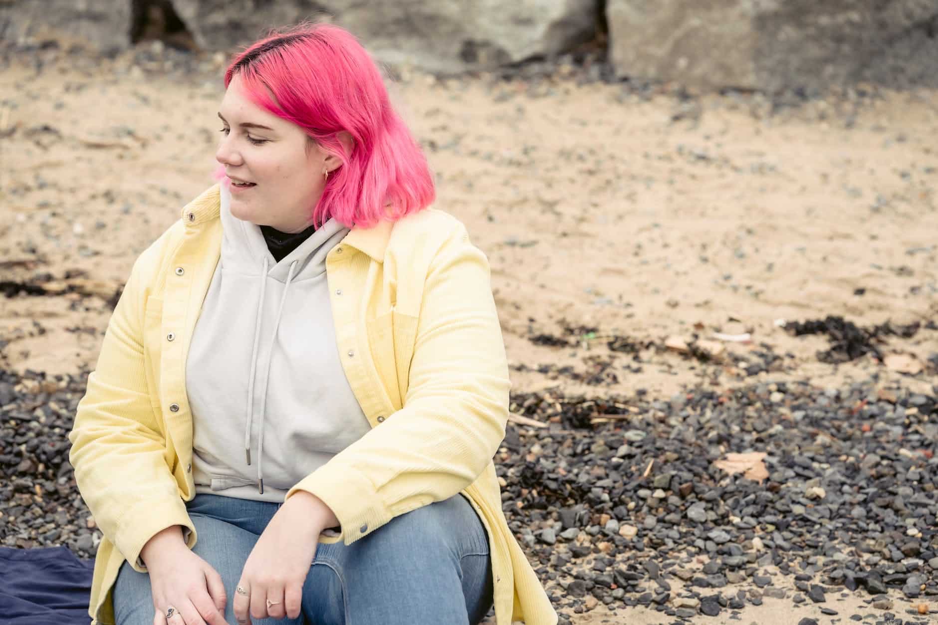 cheerful plump woman sitting on beach